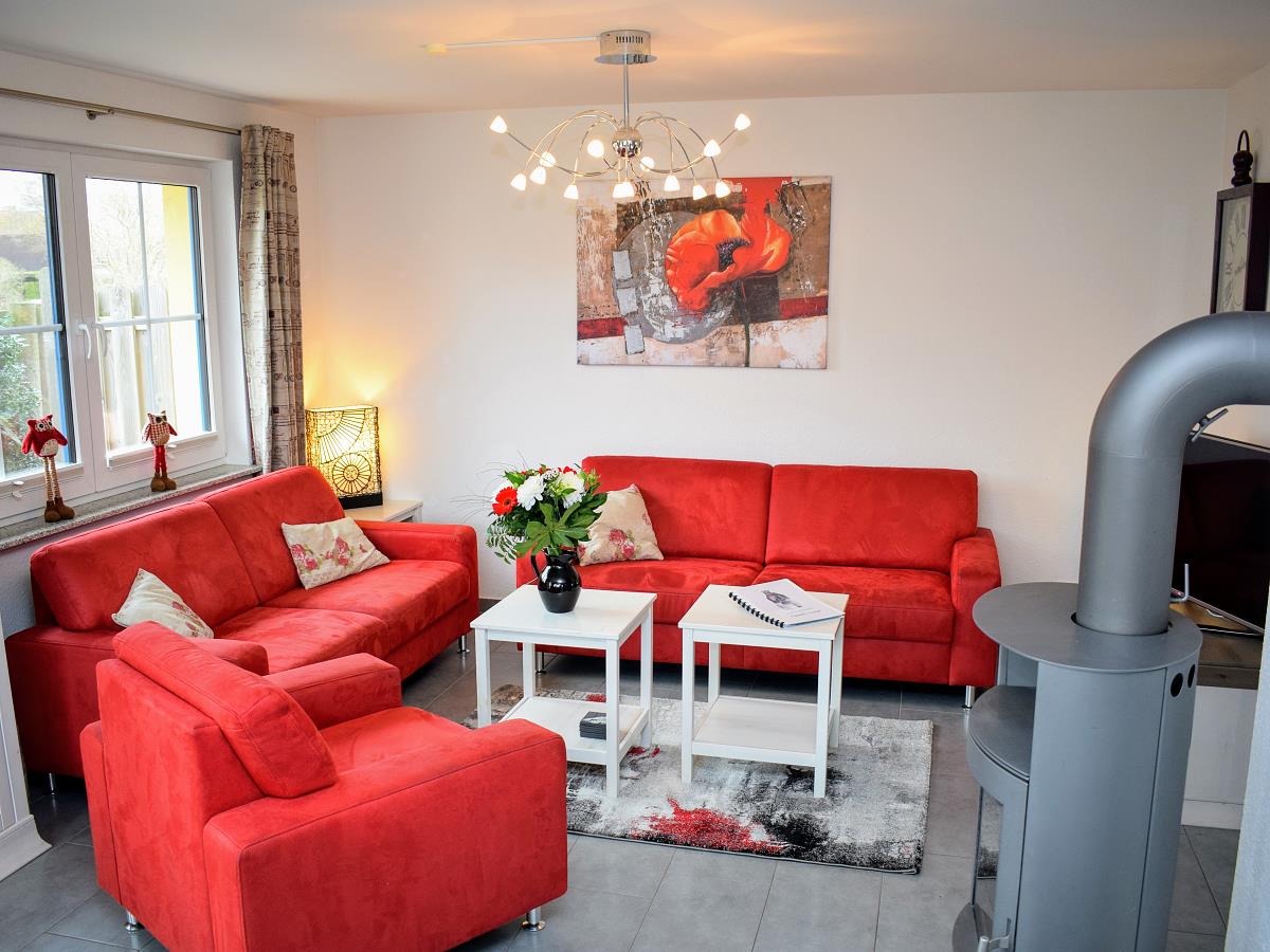 Wohnzimmer mit Couch, Sessel, TV, Kamin, Tisch